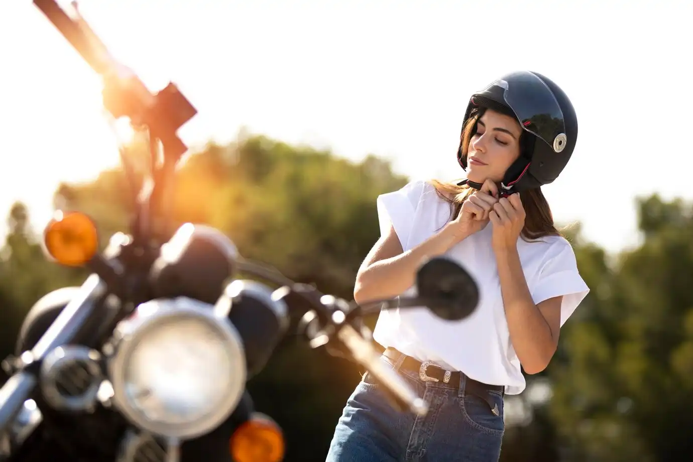 woman putting helmet motorcycle road trip